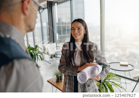 A dynamic business meeting taking place in a modern office setting featuring presentation materials A dynamic business meeting taking place in a modern office setting featuring presentation materials 125407627