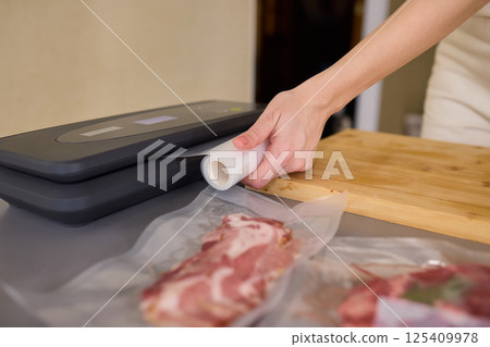 Hands Skillfully Preparing Vacuum Sealing for Food Preservation and Storage Purposes Hands Skillfully Preparing Vacuum Sealing for Food Preservation and Storage Purposes 125409978