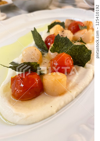 Fried Portuguese scallops in white wine sauce with lemon, tomatoes and toast. Seafood. Fried Portuguese scallops in white wine sauce with lemon, tomatoes and toast. Seafood. 125410192