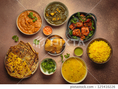 Traditional assorted Indian dishes top view on rustic brown background table. Cuisine of India 125410226