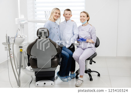 Mother and son smiling with dentist in dental clinic 125410324