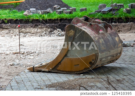 Detached bucket of the escort lying on the ground Detached bucket of the escort lying on the ground 125410395