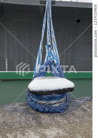 Tied rope on the knot around the mooring bollard. Nautical theme background 125410469