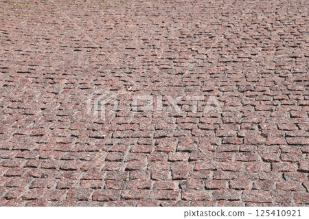 Red granite pavement. Granite pavers, red stone, granite background. 125410921