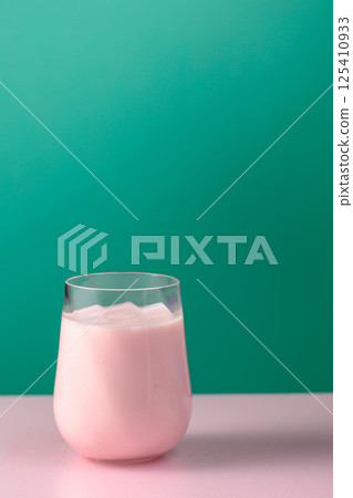 Pink smoothie, vitamin drink, or yogurt on a colorful background. 125410933