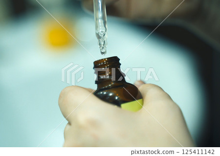 Extracting liquid for dental treatment in a clinical setting during daylight Extracting liquid for dental treatment in a clinical setting during daylight 125411142