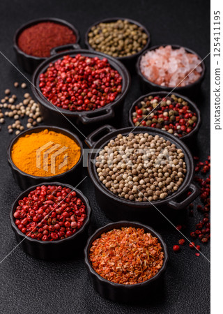 Variations of spices, allspice, turmeric, paprika, salt in ceramic bowls 125411195