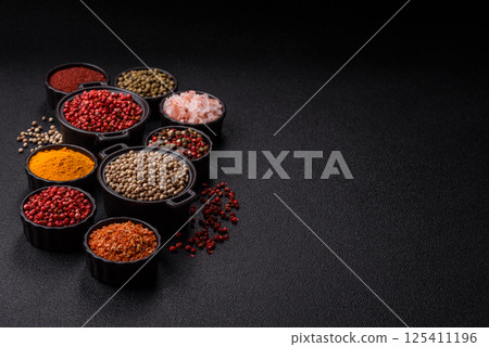 Variations of spices, allspice, turmeric, paprika, salt in ceramic bowls 125411196