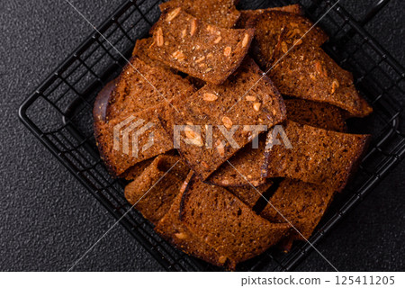 Crispy homemade brown bread chips with seeds and grains, salt, spices Crispy homemade brown bread chips with seeds and grains, salt, spices 125411205