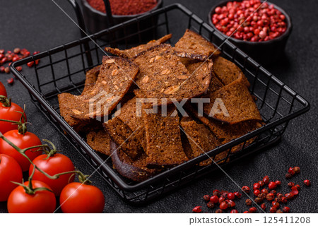 Crispy homemade brown bread chips with seeds and grains, salt, spices Crispy homemade brown bread chips with seeds and grains, salt, spices 125411208