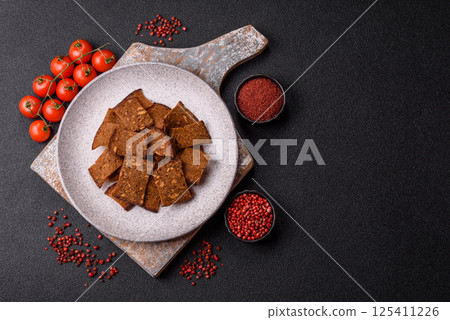 Crispy homemade brown bread chips with seeds and grains, salt, spices 125411226