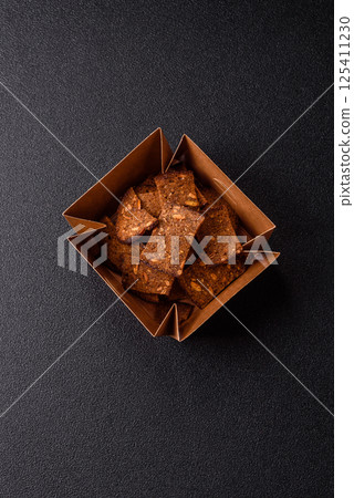 Crispy homemade brown bread chips with seeds and grains, salt, spices Crispy homemade brown bread chips with seeds and grains, salt, spices 125411230