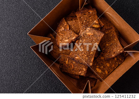 Crispy homemade brown bread chips with seeds and grains, salt, spices 125411232