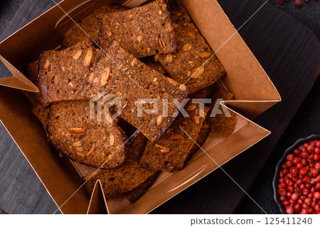 Crispy homemade brown bread chips with seeds and grains, salt, spices 125411240