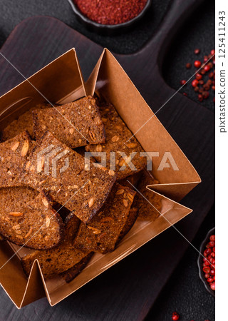 Crispy homemade brown bread chips with seeds and grains, salt, spices 125411243