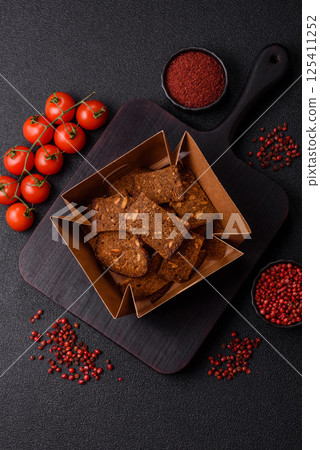 Crispy homemade brown bread chips with seeds and grains, salt, spices 125411252