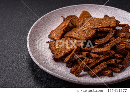 Crispy homemade brown bread crackers or croutons with seeds and grains 125411377