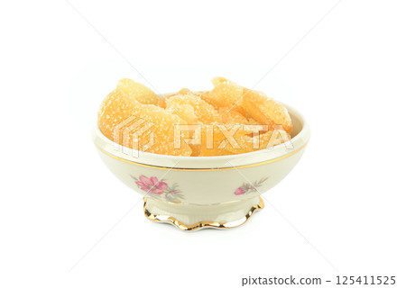 Candied ginger in a porcelain bowl isolated on white. 125411525
