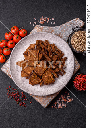 Crispy homemade brown bread crackers or croutons with seeds and grains Crispy homemade brown bread crackers or croutons with seeds and grains 125411641