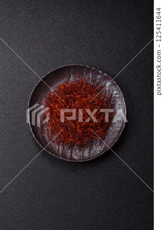 Red thin hot chili threads on a dark background 125411644