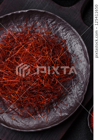 Red thin hot chili threads on a dark background 125411650