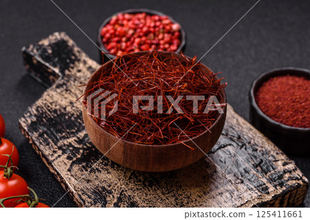 Red thin hot chili threads on a dark background Red thin hot chili threads on a dark background 125411661