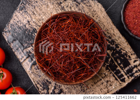 Red thin hot chili threads on a dark background Red thin hot chili threads on a dark background 125411662