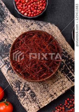 Red thin hot chili threads on a dark background Red thin hot chili threads on a dark background 125411663