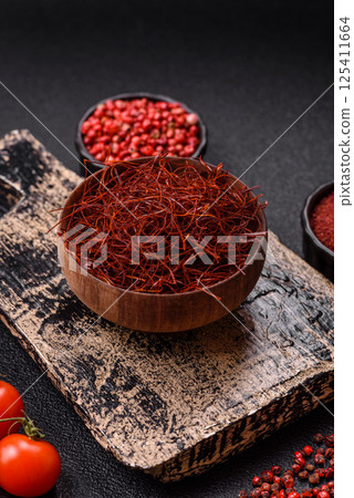 Red thin hot chili threads on a dark background 125411664
