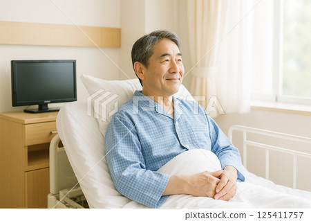 一名日本男性患者在病房裡平靜地度過時光 一名日本男性患者在病房裡平靜地度過時光 125411757