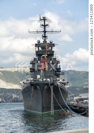 Novorossiysk, Russia - 18 August 2023. Cruiser Mikhail Kutuzov and dolphins, Black Sea, port, Krasnodar Territory, Novorossiysk. 125411809
