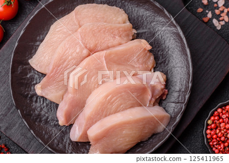 Raw chicken or turkey fillet cut into slices with salt, spices and herbs 125411965