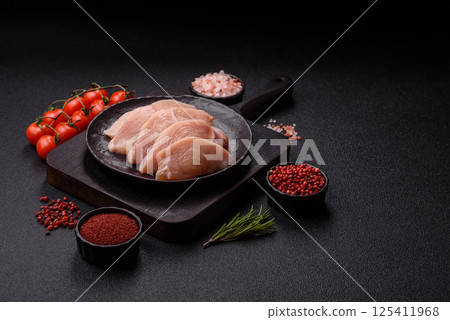 Raw chicken or turkey fillet cut into slices with salt, spices and herbs Raw chicken or turkey fillet cut into slices with salt, spices and herbs 125411968