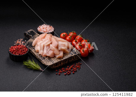 Raw chicken or turkey fillet cut into slices with salt, spices and herbs Raw chicken or turkey fillet cut into slices with salt, spices and herbs 125411982