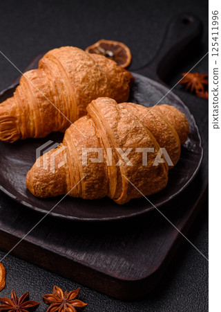 Sweet crispy croissants with chocolate filling 125411996