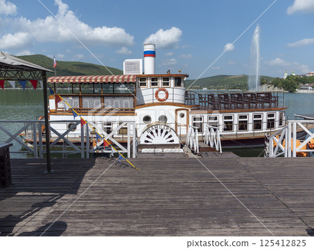 Abrau Durso, Russia 28 August 2024: The retro steamship Champagne is moored at the pier on the embankment of Lake Abrau-Durso 125412825