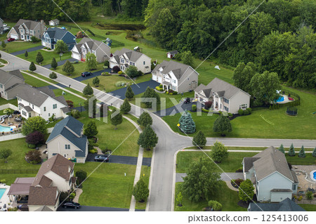Low-density two story private homes in rural residential suburbs outside of Rochester, New York. Upscale suburban houses with large lot size and green grassy lawns in summer season 125413006