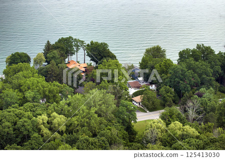 Large waterfront private homes in Rochester, NY residential area on lakeside Ontario. New family houses as example of real estate development in American suburbs Large waterfront private homes in Rochester, NY residential area on lakeside Ontario. New family houses as example of real estate development in American suburbs 125413030