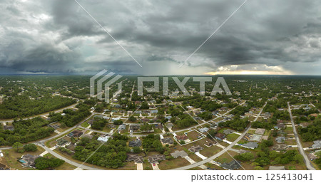 Landscape of dark ominous clouds forming on stormy sky during heavy thunderstorm over rural town area 125413041