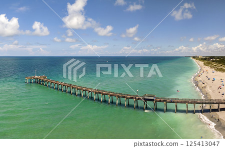 Idyllic summer day over sandy beach at Venice fishing pier in Florida. Summer seascape with surf waves crashing on sea shore Idyllic summer day over sandy beach at Venice fishing pier in Florida. Summer seascape with surf waves crashing on sea shore 125413047
