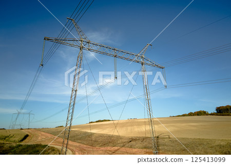High voltage tower with electric power lines transfening electrical energy through cable wires 125413099