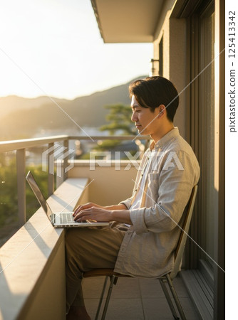Japanese man working in the sunshine on a balcony (AI generated image) Japanese man working in the sunshine on a balcony (AI generated image) 125413342