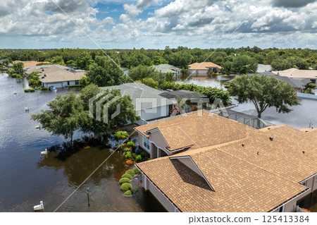 Flooding in Florida caused by tropical storm from hurricane rainfall. Suburb houses in residential community surrounded by flood waters. Aftermath of natural disaster Flooding in Florida caused by tropical storm from hurricane rainfall. Suburb houses in residential community surrounded by flood waters. Aftermath of natural disaster 125413384
