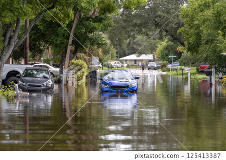 Flooded street with stuck cars after hurricane rainfall in Florida. Aftermath of natural disaster caused by global warming Flooded street with stuck cars after hurricane rainfall in Florida. Aftermath of natural disaster caused by global warming 125413387