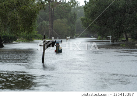 Flooded Florida road in suburban residential area. Driving hazard. Aftermath of hurricane natural disaster Flooded Florida road in suburban residential area. Driving hazard. Aftermath of hurricane natural disaster 125413397