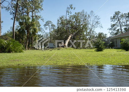 Flooded empty street after hurricane rainfall in Florida residential area. Consequences of natural disaster 125413398