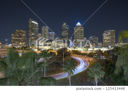 Downtown of Tampa city in Florida, USA. Car traffic on highway road and brightly illuminated high skyscraper buildings. American travel destination 125413446