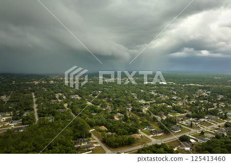Dark stormy clouds forming on gloomy sky before heavy rainfall over suburban town area Dark stormy clouds forming on gloomy sky before heavy rainfall over suburban town area 125413460