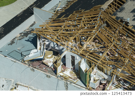 Damaged house roof and walls after hurricane Ian in Florida. Consequences of natural disaster Damaged house roof and walls after hurricane Ian in Florida. Consequences of natural disaster 125413473