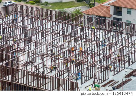 Construction site with many workers and equipment in Fort Myers, Florida. Hard labor employment at commercial development Construction site with many workers and equipment in Fort Myers, Florida. Hard labor employment at commercial development 125413474